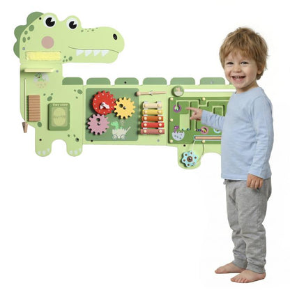 Green dinosaur Montessori busy board with gears, sliders, and maze panels on wall