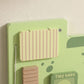 Green dinosaur busy board close-up of wooden slat panel and striped flap window