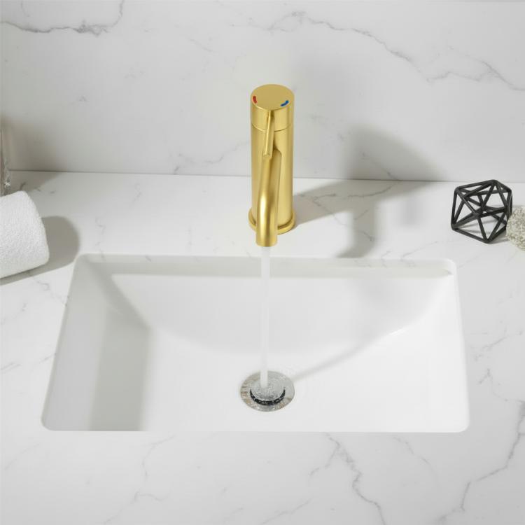 Brushed gold single-hole bathroom faucet installed on white sink with water flow