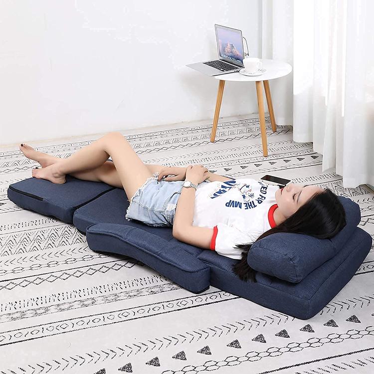 Blue adjustable floor chaise lounge chair reclined with head and waist support pillows.