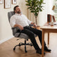 Light grey high-back executive office chair with wide seat, padded arms, rolling casters