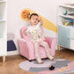 Pink toddler sofa chair with child seated; tufted heart backrest and rhinestone buttons