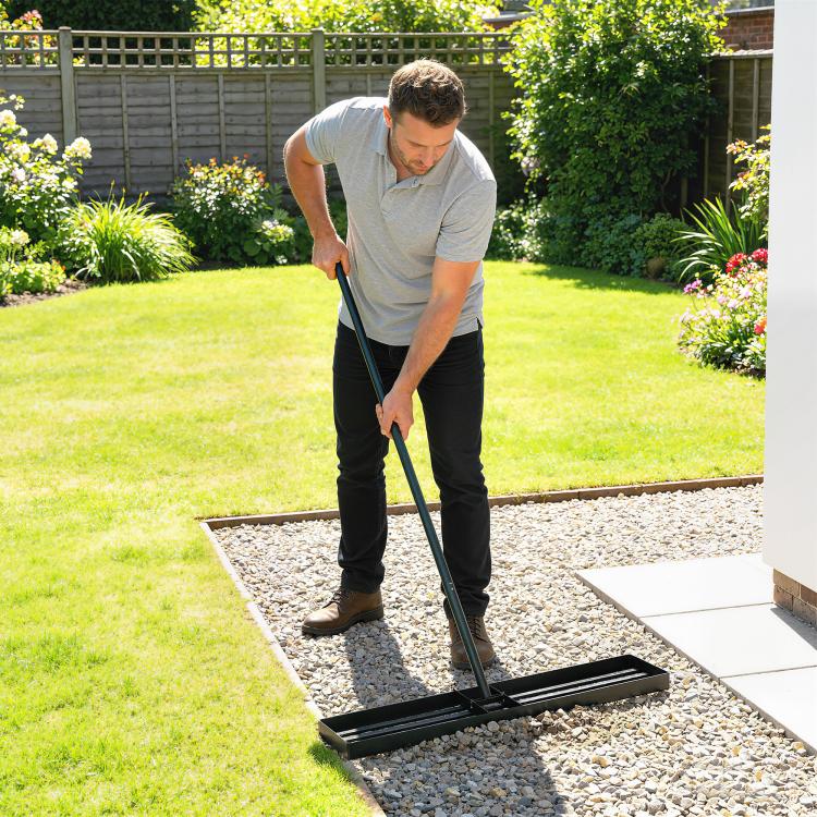Lawn leveling rake with long handle and wide black base with parallel leveling bars