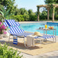 Blue striped outdoor lounge chair with face pillow and metal frame by the pool