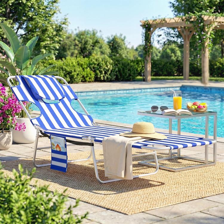 Blue striped outdoor lounge chair with face pillow and metal frame by the pool