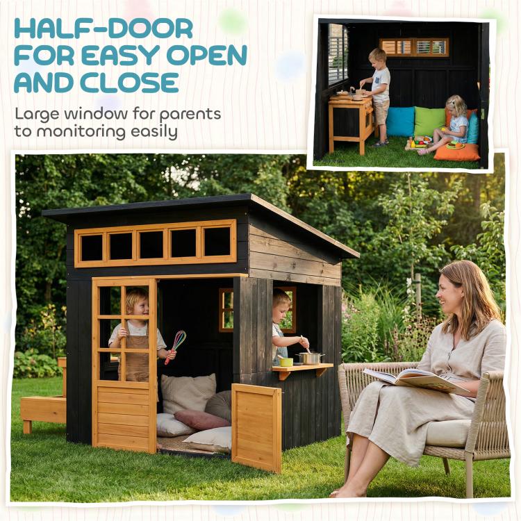 Black wooden playhouse with half-door and large windows, plus side picnic table