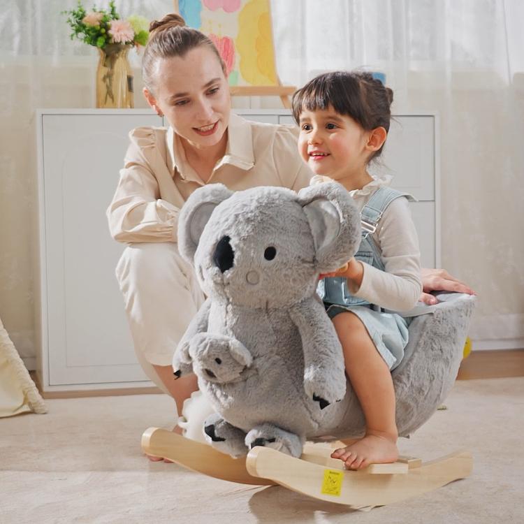 Gray plush koala rocking horse with wooden base, child seated on rocker