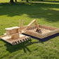 Wooden kids sandbox with sand and attached wooden digger tool on base