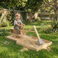 Wooden kids sandbox with rotating seat and digger, child seated on the play platform