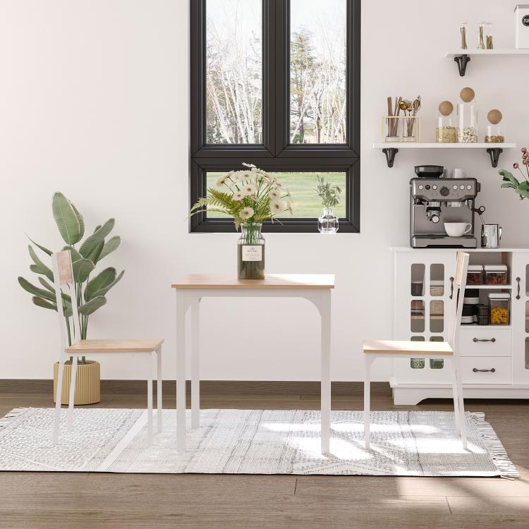 White dining table and two wood-tone chairs with square tabletop in a bright room.