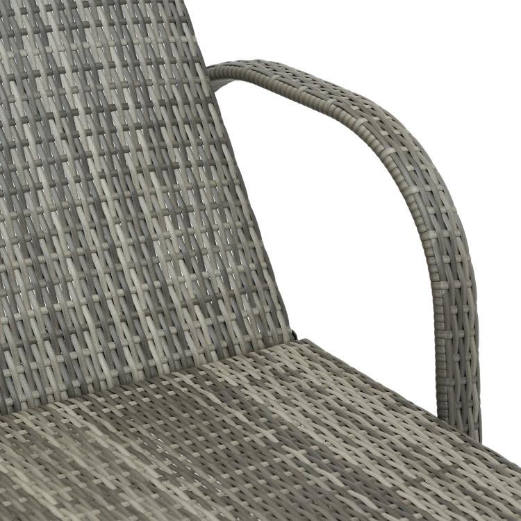 Curved woven rattan arm and backrest of a gray cushioned outdoor chaise lounge