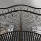 Close-up of dark bronze arched scrollwork panel on a metal garden bridge side rail.
