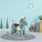 Blue plush rocking horse with bear plush and gray rocking base on floor