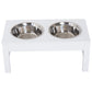 White raised pet feeding stand with two stainless steel bowls on square legs