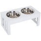 White elevated dog bowl stand with two stainless bowls and side cutout panels