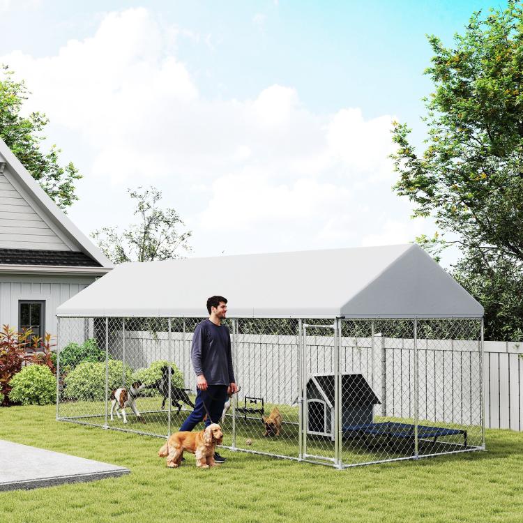 Outdoor dog kennel with chain-link panels, grey roof, and kennel door
