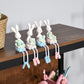 Walnut top shelf of a 4-tier bookshelf with bunny figurines and stationery