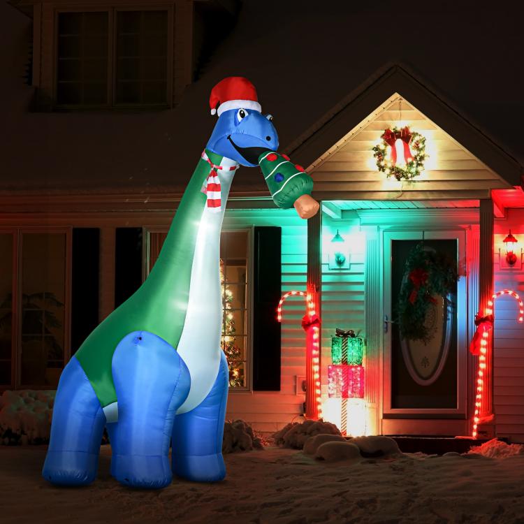 LED-lit inflatable dinosaur with Christmas tree in mouth, standing outdoors