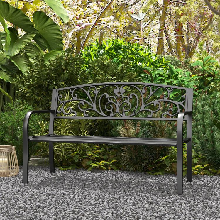 Black metal garden bench with ornate scrollwork backrest and slatted seat, armrests