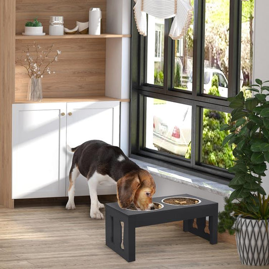 Black elevated dog feeding station with two stainless-steel bowls; dog eating
