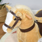 Light brown plush horse head with dark bridle and wooden handle, close-up