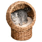 Light brown woven cat dome bed with plush cushion and gray tabby cat inside