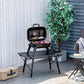 Black portable charcoal grill with lid open, food cooking on top grate outdoors