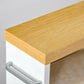 Light wood cabinet top with white front panel and built-in storage rail