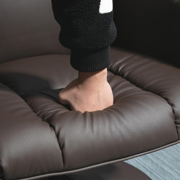Close-up of dark brown padded PU leather recliner seat cushion and armrest