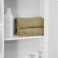 White bathroom medicine cabinet with mirror door and open shelves, folded towels