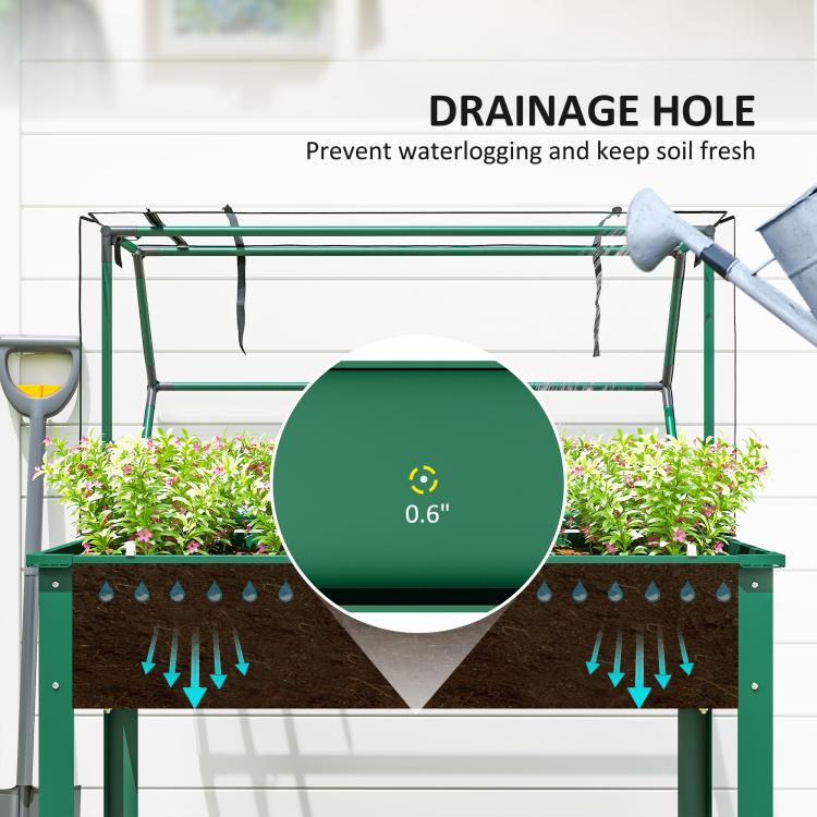 Green raised bed with greenhouse cover showing drainage hole for plant soil