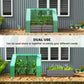 Green mini greenhouse raised bed with dark gray planter walls in front of building