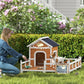 Outdoor wooden dog house with arched door and side porch, dogs standing in front