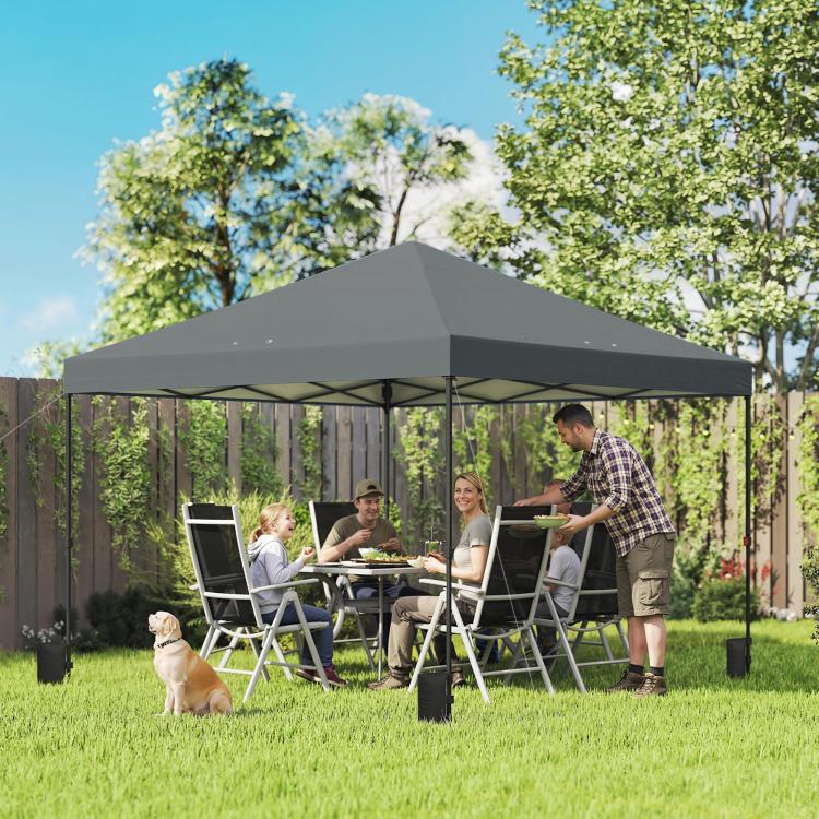 Dark gray pop-up canopy tent shelter outdoors with seating and table underneath