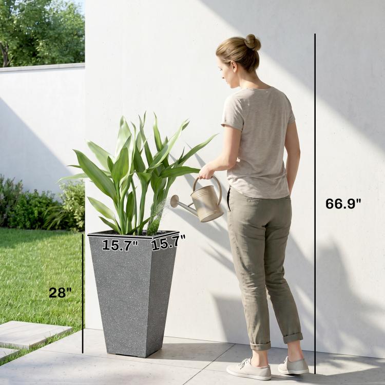 Tall gray tapered plastic planter with green plant next to person for scale