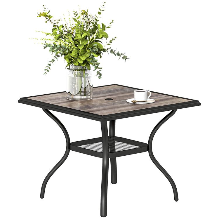 Square outdoor dining table with gray faux-wood top, umbrella hole, and curved black legs