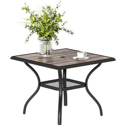 Square outdoor dining table with gray faux-wood top, umbrella hole, and curved black legs