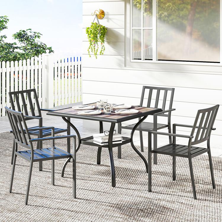 Square outdoor dining table with gray top and black metal legs on patio