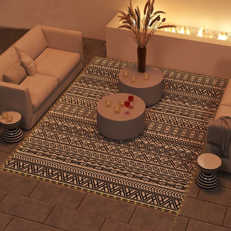 Outdoor rug carpet with black-and-white geometric pattern and warm LED border lights