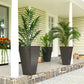 Tall outdoor planters set of 3 with dark speckled finish, holding green potted plants