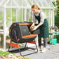 Outdoor compost tumbler on stand, open black drum with orange trim and interior food waste