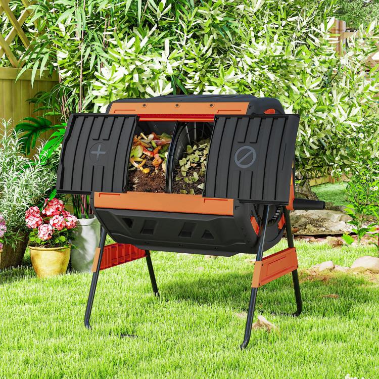 Outdoor dual-chamber compost tumbler bin with open black doors and orange accents on grass
