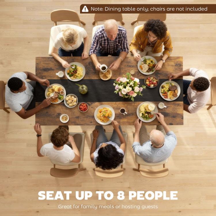 Rectangular dining table designed for group meals, styled with dinner plates and flowers