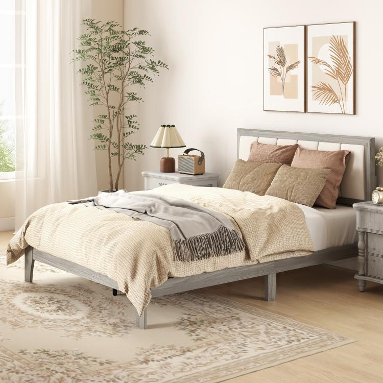 Gray platform bed with tufted upholstered headboard and beige throw blanket