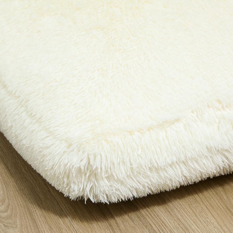 Cream white plush shag fabric on the edge of the floor sofa bed mattress
