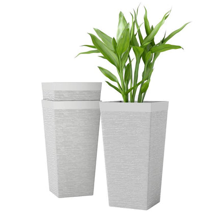 Set of three white stone-finish outdoor planters, tapered square pots