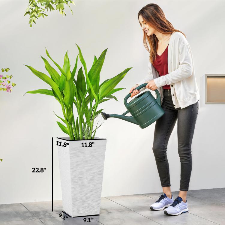 White tapered stone-finish planter with drainage hole, shown with watering can