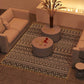 Outdoor patio rug with black-and-white geometric pattern laid on the floor.