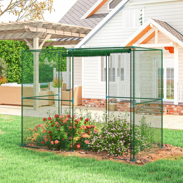 Green mesh garden crop cage with frame and front opening beside house