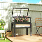 Gray elevated planter box with open flip-up mini greenhouse over flower bed